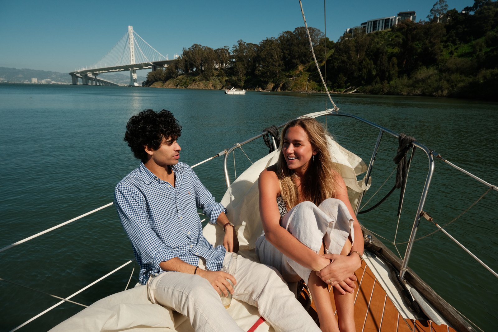 Two models seated at the bow of a sailboat.